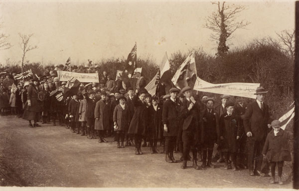 Photograph of a march with many people in it. Several banners and flags one banner states 'Where's there a will there's a way'